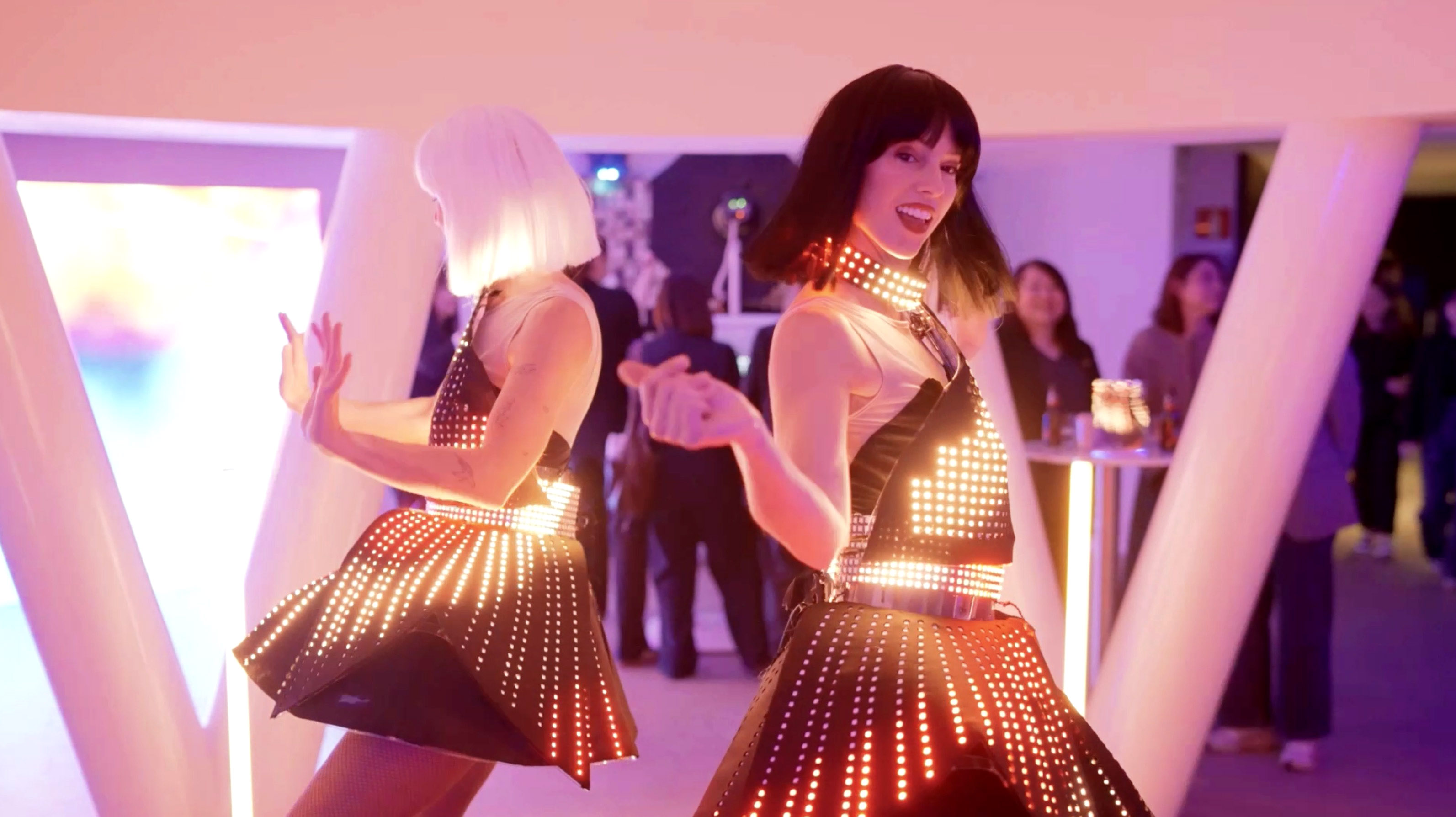 Immersive brand activation event with event entertainers wearing LED dresses in a orange-lit room