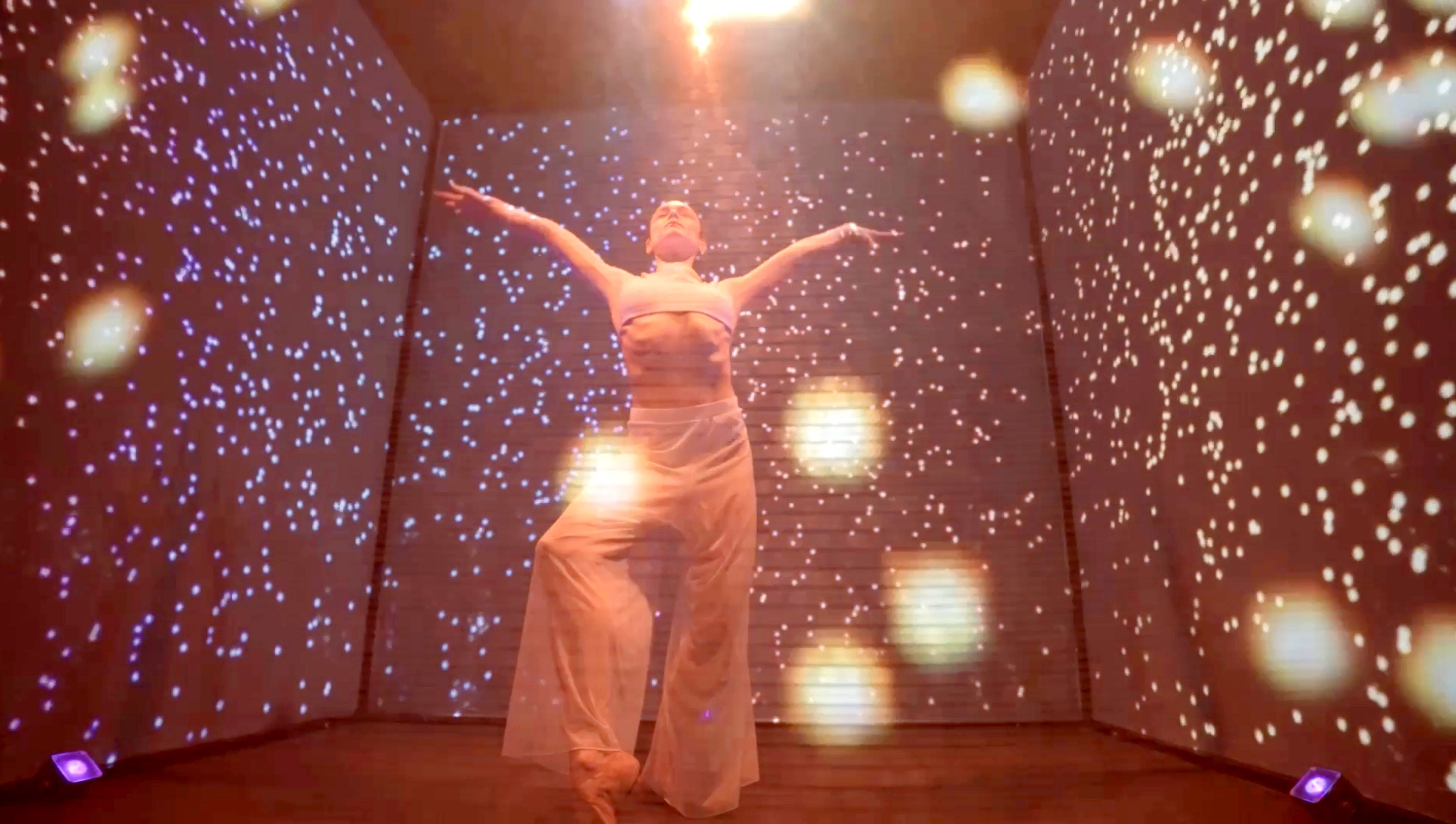 Live performer interacting with a large, projection-mapped digital cube displaying gaming brand assets at an event.