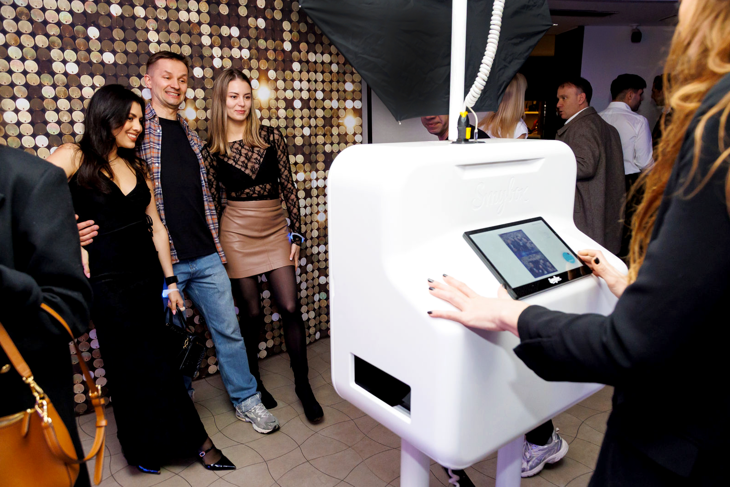 Guests posing in an ai photobooth with a shimmer backdoor at a VIP Brand partnership event