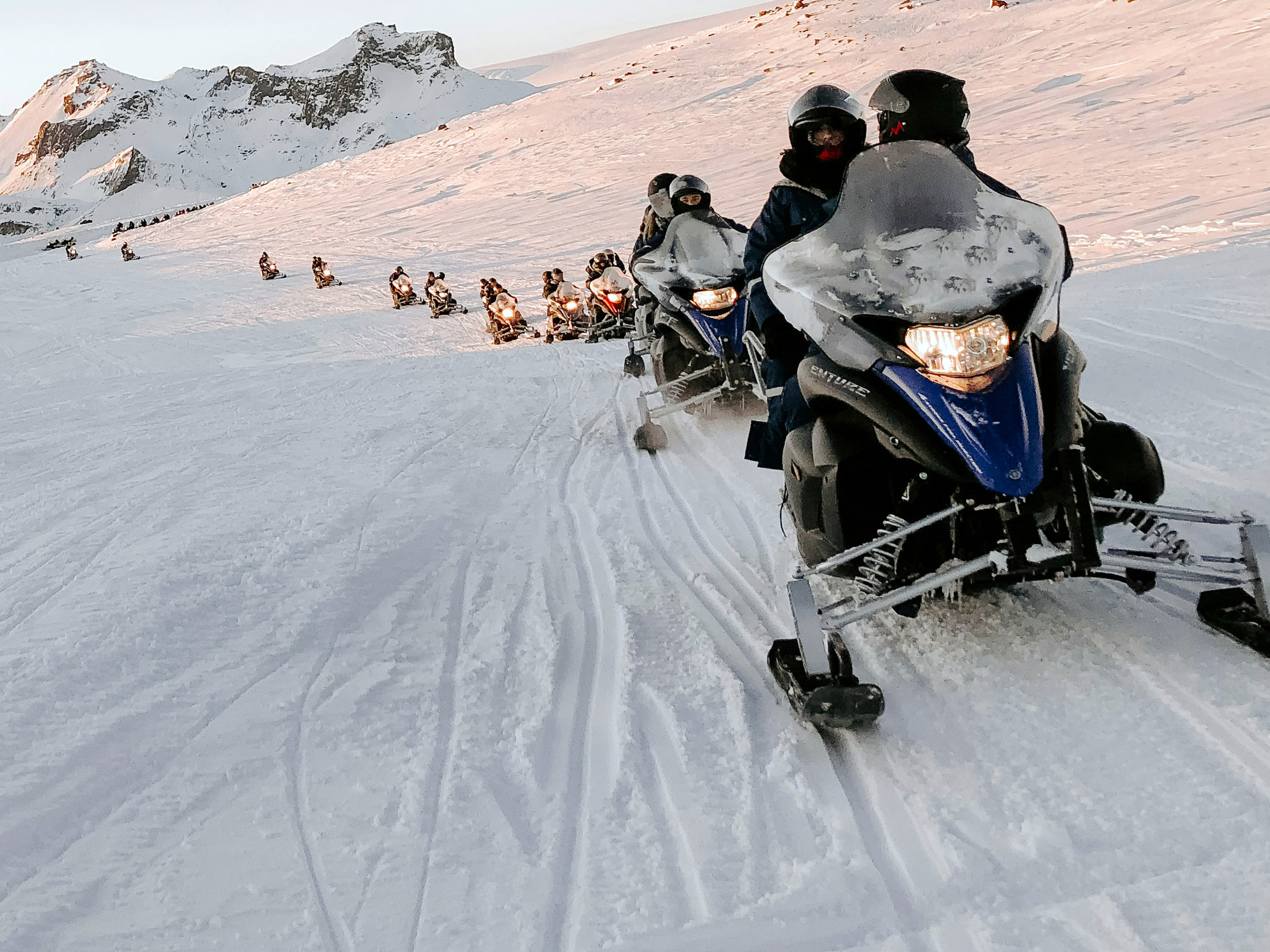 Corporate event team participating in a snowmobile excursion in an Alpine mountain
